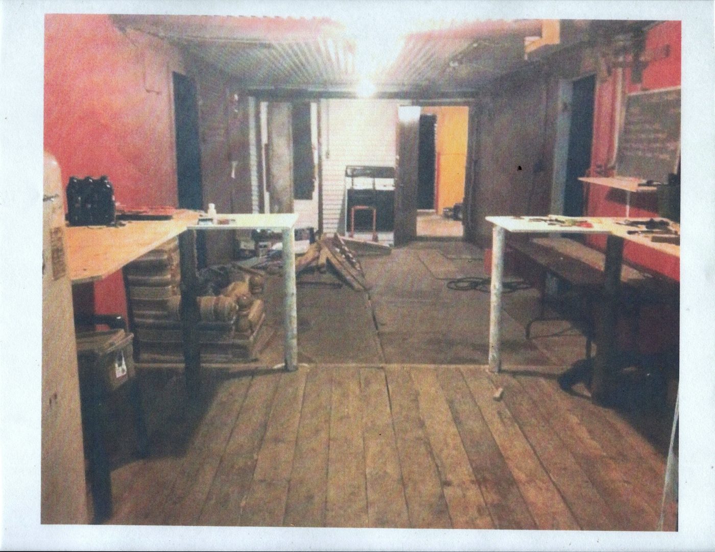 The bunker's common room, January 2013: wooden floor, tables, stove.