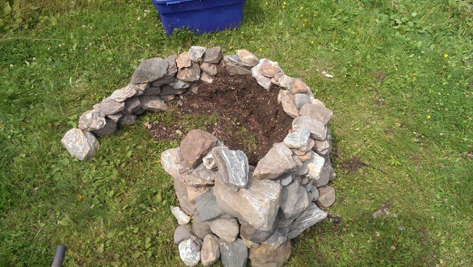 The stone fire circle, in the grass.