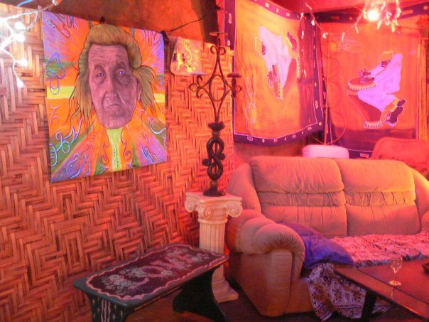 A portrait on the wall, an orange sofa, red light.