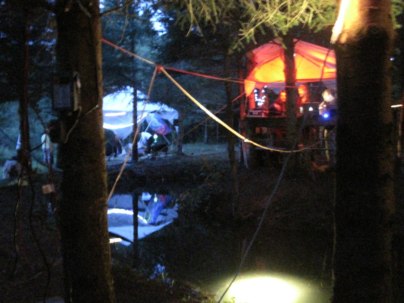 The tents and the lights reflected in the water.