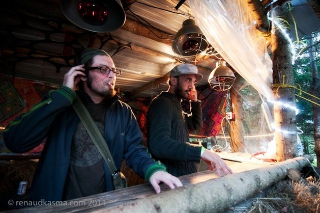 Two DJs in the same round-log booth, under the caged lamps, 2011. Photo Renaud Kasma, reused on the Tatanka 2013 page of ledonjon.ca.